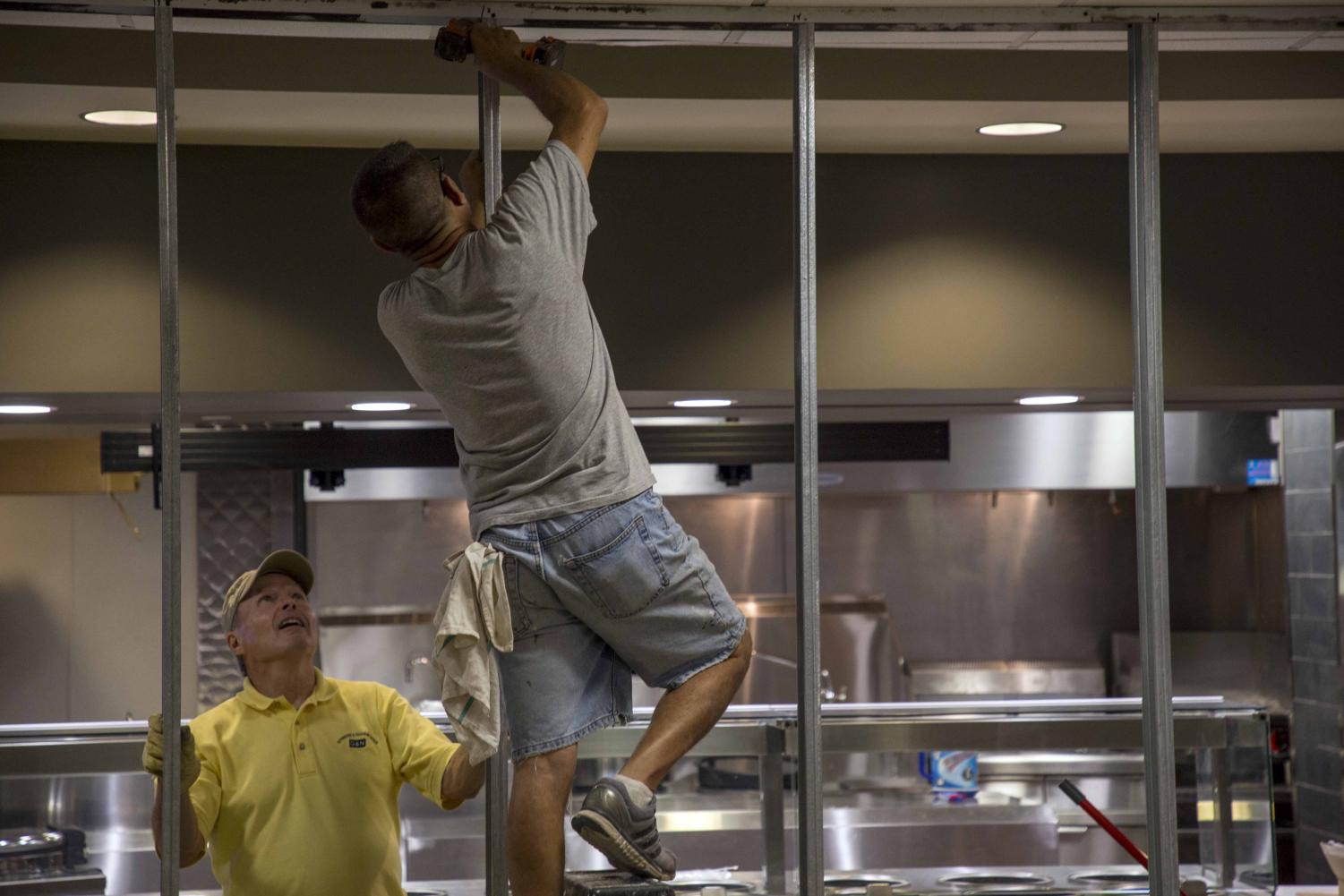 Construction crew members install paneling for Panda Express. Panda Express will open early next week in the Rhatigan Student Center.