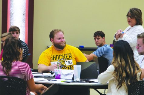 SGA Senator Michael Bearth interacts with other student senators and Vice President for Student Affairs Teri Hall at an SGA meeting in the Rhatigan Student Center.