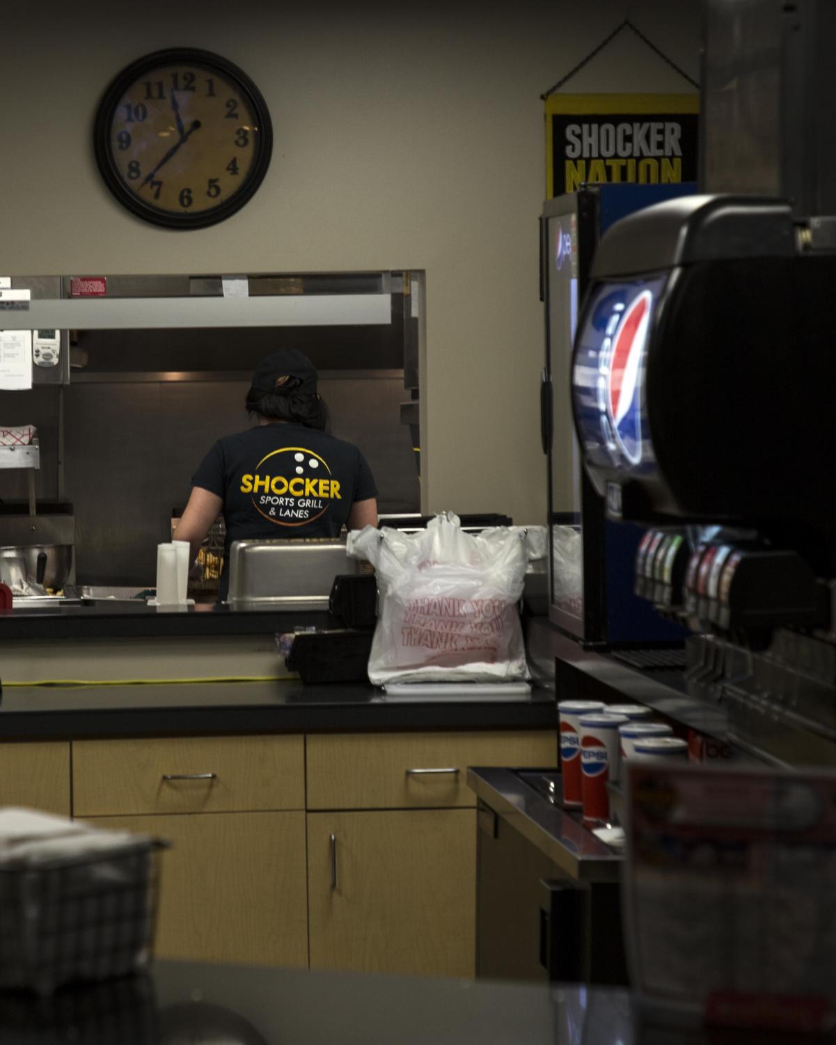 An employee prepares food for Shocker Sports Grill and Lanes customers. Shocker Sports Grill and Lanes is located in the basement of the Rhatigan Student Center.