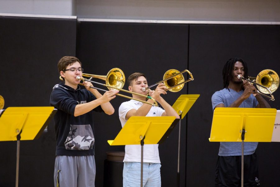 Jack Tobias (middle) plays the trombone during rehearsal in Koch Arena for the Wichita State Marching Band on Sept. 20, 2018.