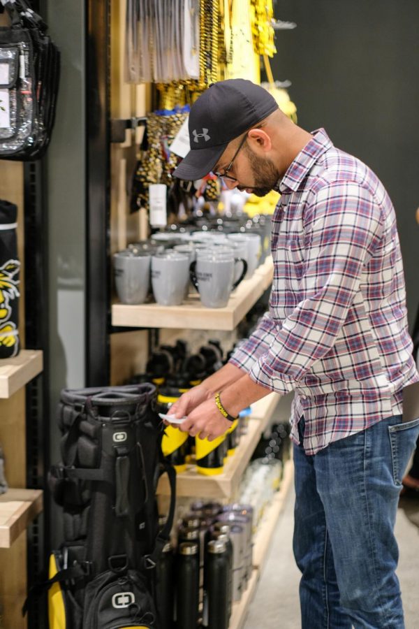 Waseen Mohammed, a graduate student majoring in Mechanical Engineering, checks the price of a golf bag.
