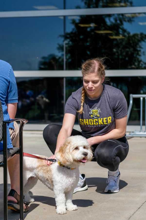 Alayna Maslinski, a sophomore majoring in Exercise Science and Biology, plays with Mitty, a Cavachon dog, at Love On A Leash outside of Study Hall, on Friday, Oct. 5, 2018.