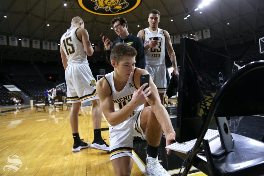 Players at Wichita State look through photos from media day at Wichita State.