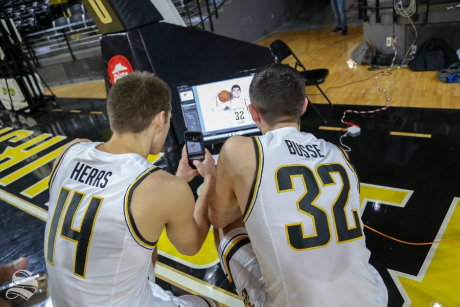 Herrs and Busse look through photos from media day at Koch Arena.