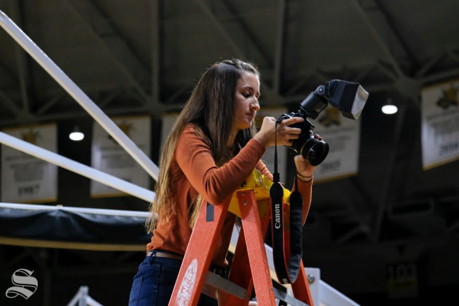The Sunflower Photo Editor, Selena Favela, takes photos from the ladder in Koch Arena.