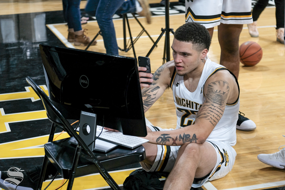 Wichita State forward Teddy Allen takes photos of himself from media day on Oct. 16, 2018.