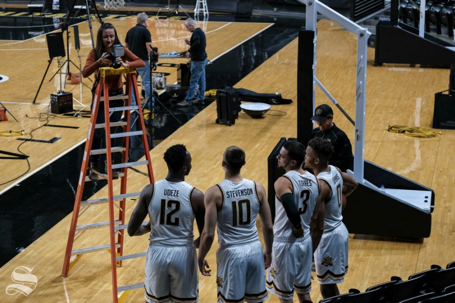 Selena Favela, the Sunflower Photo Editor, takes group photos of mens basketball players from a ladder.