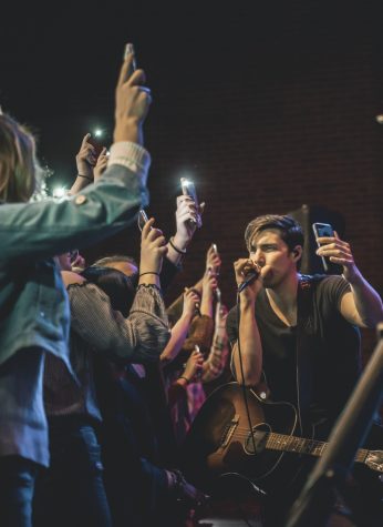 FILE PHOTO: Country music singer and song writer, John King, records a video for his Instagram story during his performance.