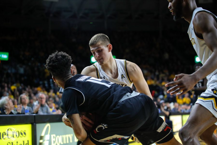 Wichita State freshman Erik Stevenson fights for the ball against Cincinnati senior Cane Broome during the game on Jan. 19, 2019 at Charles Koch Arena. Stevenson received a foul instead of a tie-up by the refs. (Photo by Joseph Barringhaus/The Sunflower).