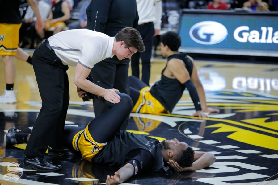 Connor Shank helps warm up players before the game against SMU on Jan. 30, 2019 at Charles Koch Arena. (Photo by Joseph Barringhaus/The Sunflower).