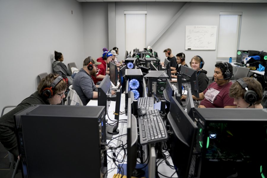 A row of gamers focus on the computers infront of them.