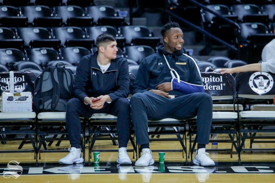 Freshman Morris Udeze sits with walk-on Tate Busse during warmups on Feb. 9, 2019.