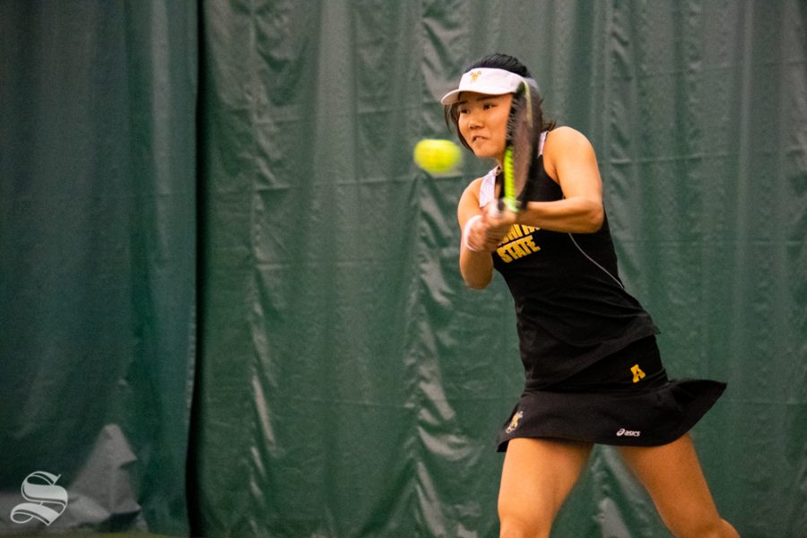 Wichita State sophomore Lingwei Kong swings for the ball during their set against Oklahoma States Lisa Marie Rioux at the Wichita Country Club tennis complex on Sunday, March 10. (Photo by Easton Thompson/The Sunflower)