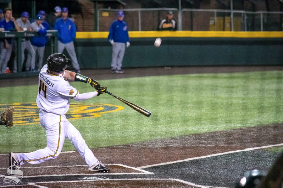 Wichita States David Vanvooren hits a fly ball that is caught by one of Kansas Universitys outfielders during their game on Wednesday, March 20. (Photo by Easton Thompson/The Sunflower).