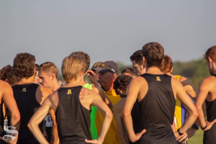 Wichita State mens cross country team meets with their coach Kirk Hunter on the field before their race on Sept. 7 at 4 Mile Creek Resort.