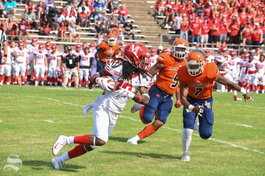 Eman McNeal, a senior tight end for the Bulldogs, runs the ball to the end zone while senior James Cox, a linebacker, and junior Quante Hayden, a defensive back, move to tackle. The game between the McPherson Bulldogs and the Langston Lions took place on Sept. 7 at Cessna Stadium.