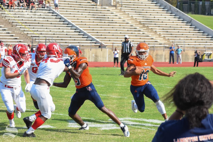 Freshman quarterback, Jordan Cooper, runs the ball around defenders during the first quarter of the game against the Bulldogs.