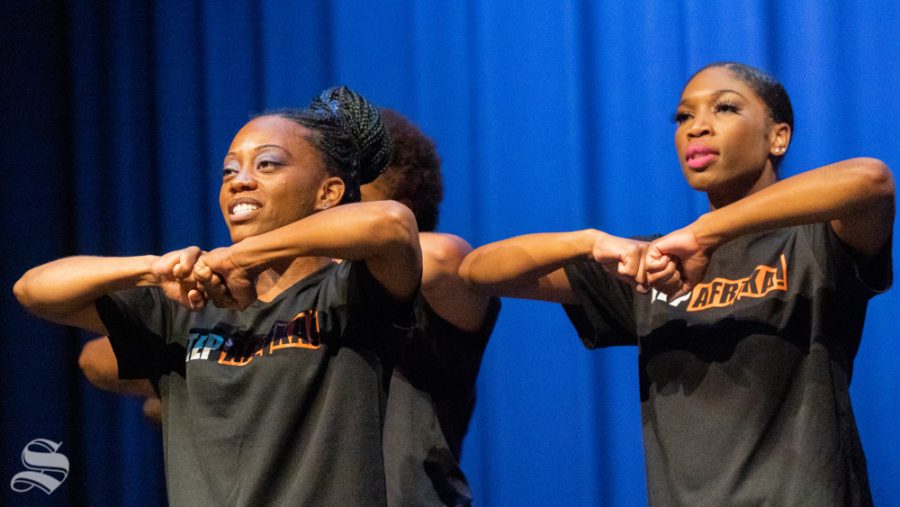 Kiera Harley (left) and Mfoniso Akpan of Step Afrika! place their fists together before a step routine.