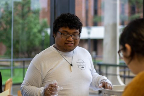 Wichita State student Richy Thach serves a Traditional southern Indian breakfast. Some of the dishes included dosa, sambar vada, and khara kadubu.