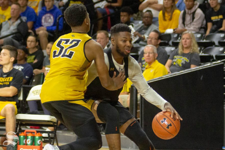 Sophomore guard Jamarius Burton dribbles past freshman Grant Sherfield during the Black and Yellow Scrimmage on Saturday inside Charles Koch Arena.