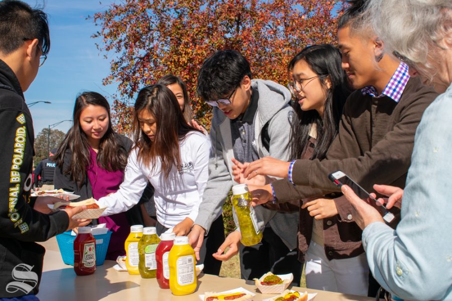 Wichita State students line up at the condiment table after getting their hot dogs during the Pop-up Picnic on Wednesday, Oct. 23 at the Duerksen Fine Arts Amphitheater.