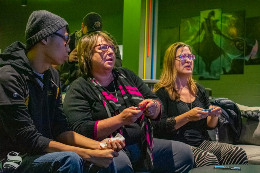 Anthony Vu watches while Teri Hall and Jessica Provines play a game on a Nintendo Switch during the opening of the WSU esports hub on Tuesday, Nov. 5 in the Heskett Center.