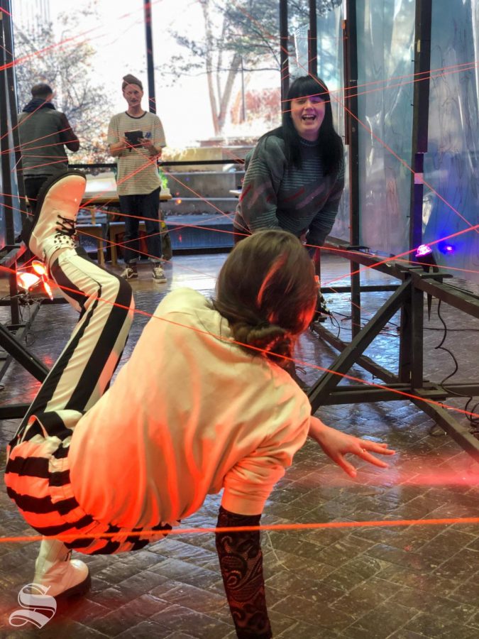 Students go through the laser maze during Draw Surge an even hosted by Art professor Robert Bubp in the McKnight Atrium on Monday December 2, 2019.