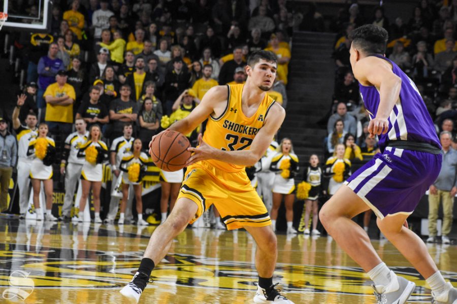 Freshman Tate Busse dribbles around a Abilene Christian defender during the second half of the game on Sunday inside Charles Koch Arena.