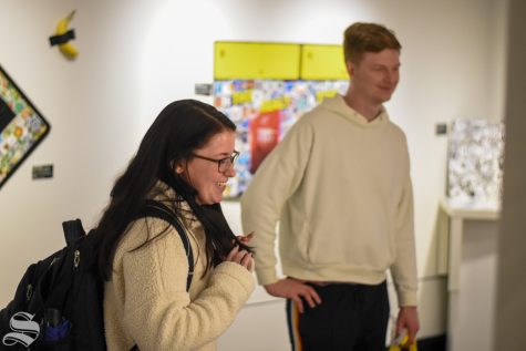 Sophia Glasgow, a junior studying and entrepreneurship and marketing, looks over Julian Kincaids art gallery in the Cadman in the RSC on Thursday, Jan. 23.