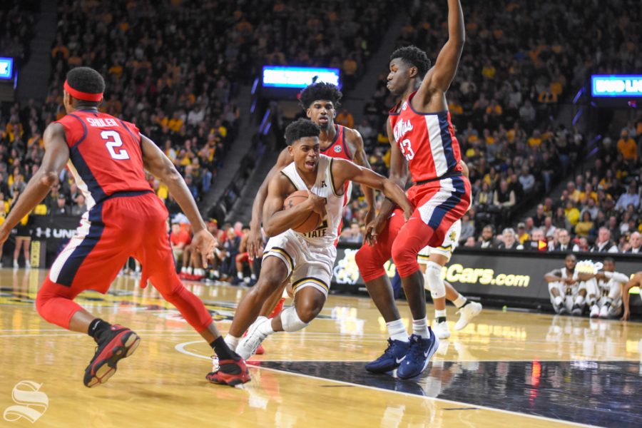 Wichita States Grant Sherfield moves past Ole Miss defenders for a basket during the game on Saturday inside Charles Koch Arena.