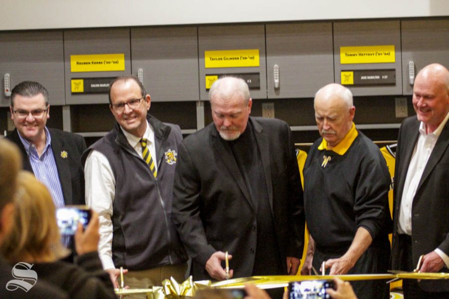 Wichita State Head Coach Eric Wedge cuts the grand opening ribbon on Friday inside the brand new baseball locker room.