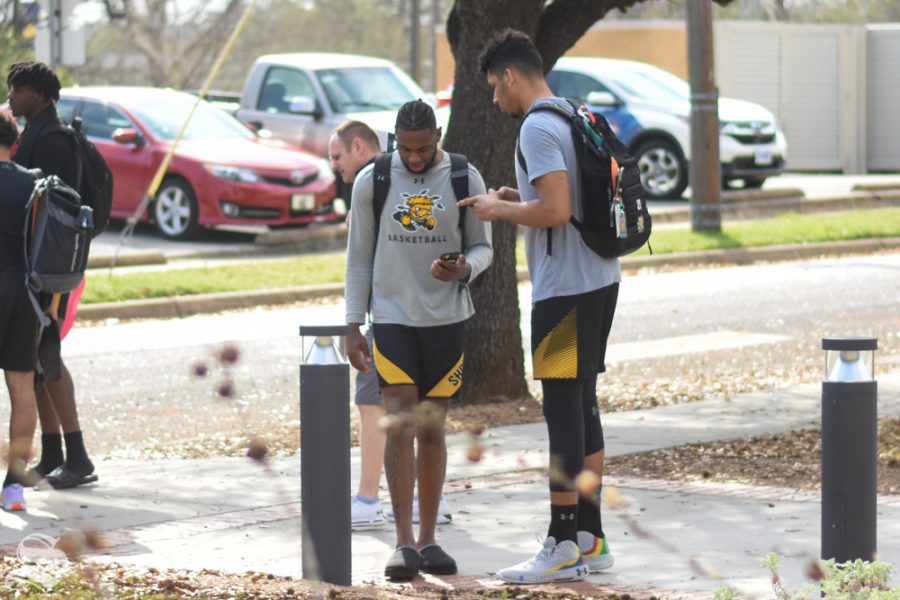 Senior Jaime Echenique and sophomore Jamarius Burton wait to load the bus outside of Texas Wesleyan after hearing the news of the AAC Tournament cancellation on Thursday, March 12.