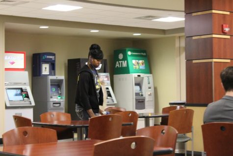 A member of the Rhatigan Student Center custodial staff wipes down tables by Starbucks.