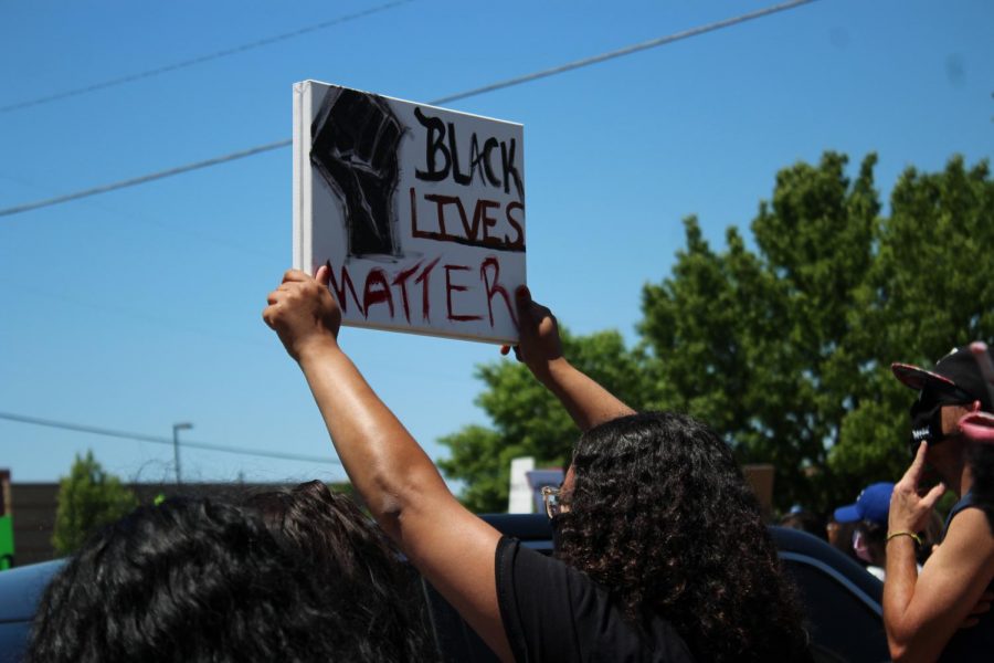 A+protester+holds+a+Black+Lives+Matter+sign+on+Saturday+during+a+protest+against+police+brutality+outside+of+a+Wichita+Police+Department+station+near+Hillside+and+21st.+The+protest+is+one+in+a+string+of+demonstrations+across+the+nation+after+George+Floyd+was+apparently+killed+by+police.
