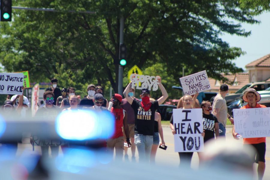 Protesters march on Saturday toward the Wichita Police Department building on 21st Street near Wichita States campus.