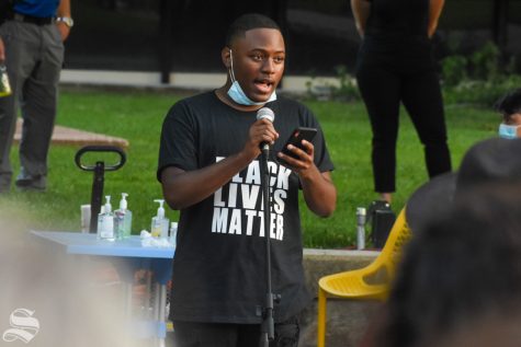 Neiman Thompson, Greek relations director for the Multicultural Greek Council, speaks during a candlelight vigil Friday night in the MGC Quad. Thompson was one of four speakers at the event.