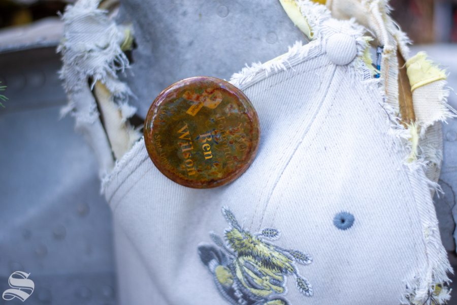 A Wichita State hat displaying a pin honoring the WSU football head coach, Ben Wilson, sits on a piece of metal from the crash at the sitee near Silver Plume, Colorado. Wilson died in the crash along with 30 other passengers.