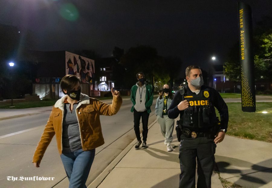 Sergeant Johnson from the University Police Department and senior Olivia Babin point out broken lights during the Safety Walk around Wichita State campus on Oct. 20.