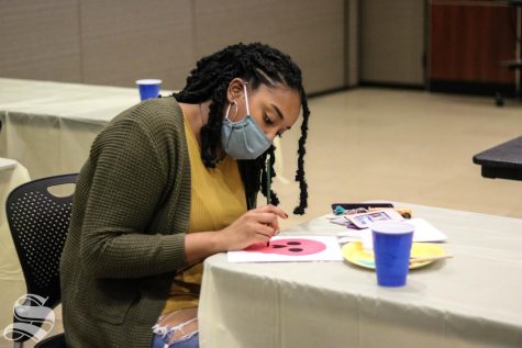 A student paints a skull for the Day of the Dead themed First Friday.