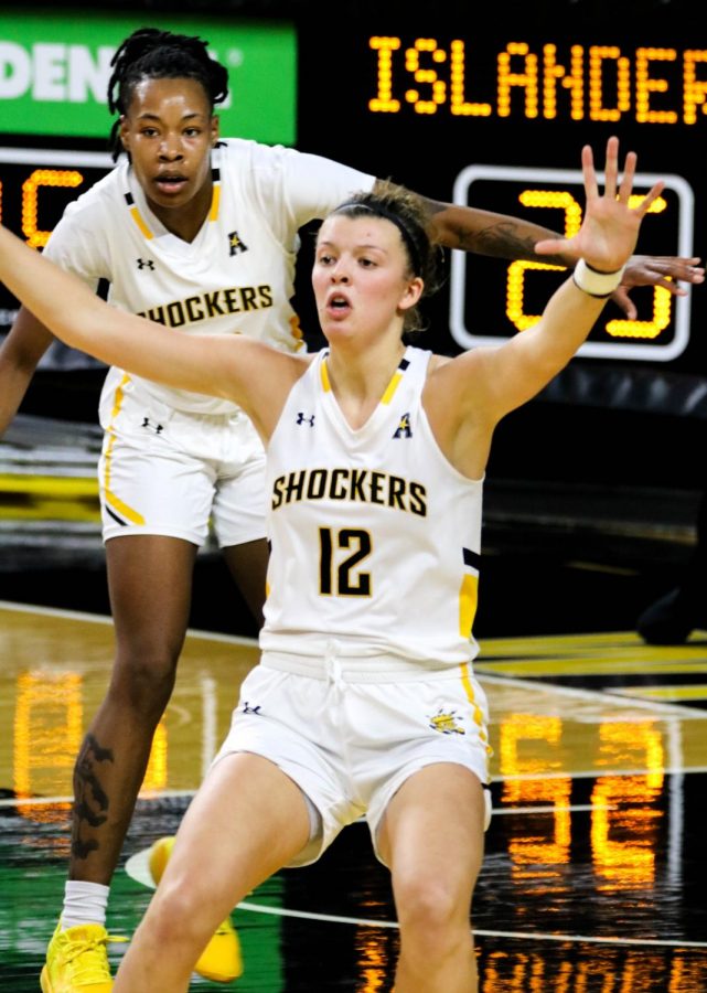 Two Wichita State basketball players, juniors Carla Bremaud and Asia Strong guard the ball during a basketball game at Charles Koch Arena on Nov. 27.
