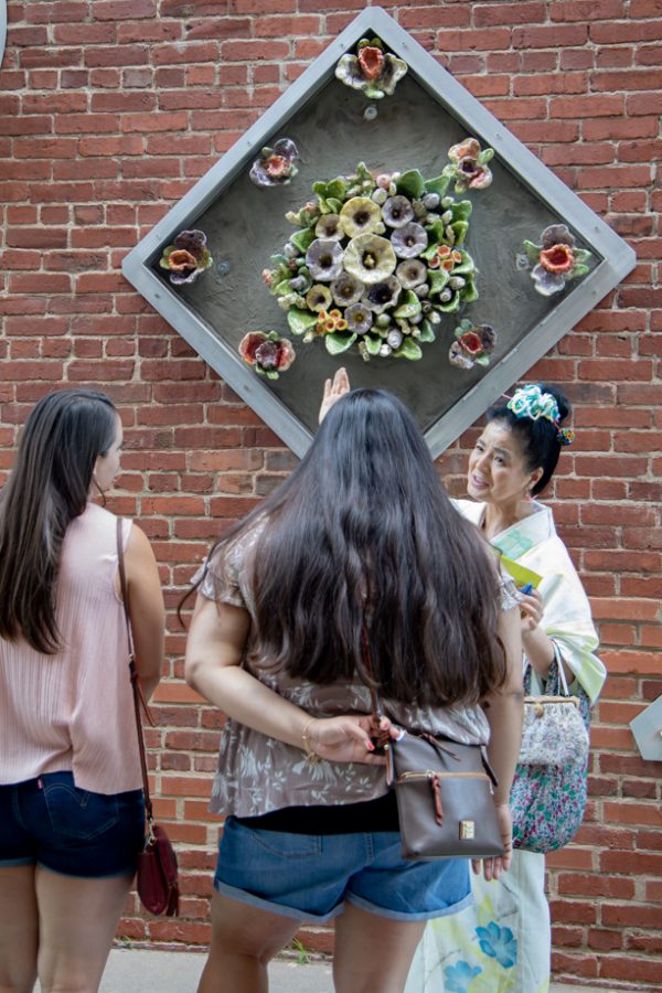 Artist Tomiyo Tajiri talks to visitors at the reopening of Gallery Alley on July 2, 2021. Tomiyo Tajiri created Maitreya.