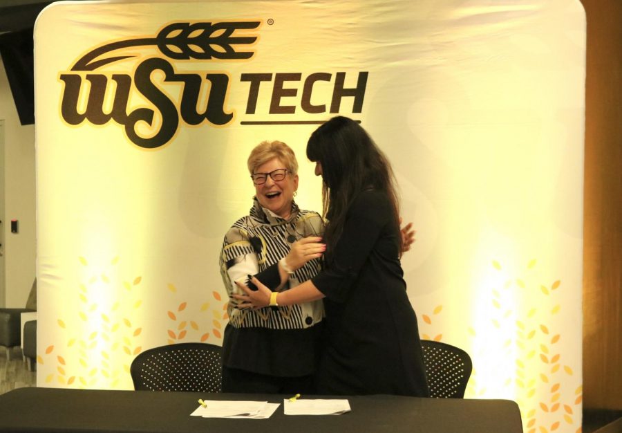 WSU Tech President Sheree Utash and dean of WSUs business school Larissa Genin hug after signing.