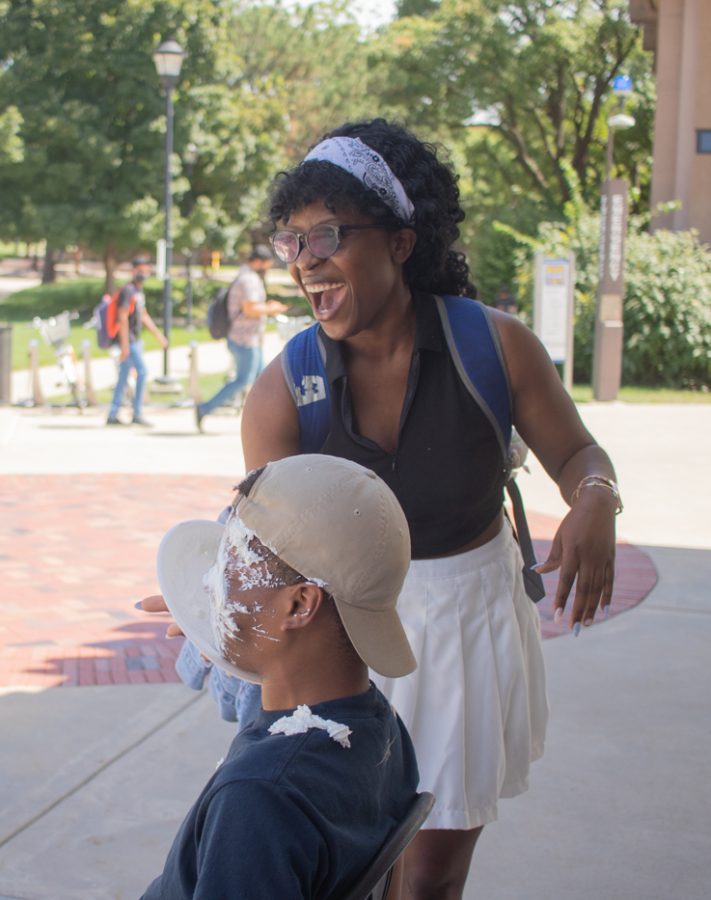 Thelma Anele Mechanical enginerring junior helps The Black Student Union by pieing one of the cabinet members during their Pie a Cabinet Member event on Aug. 23.
