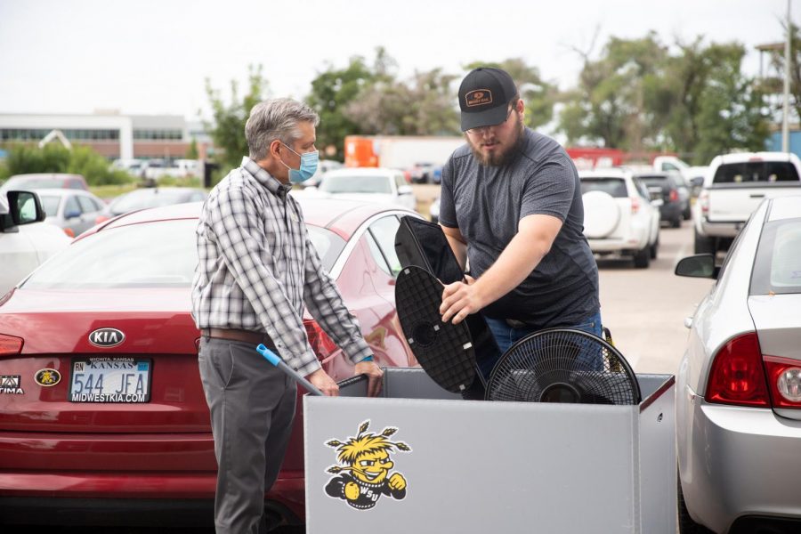 President Rick Muma helps students load up their belongings to move into The Flats at WSU on August 13