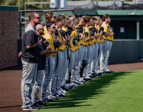 The baseball team stands in unison during the national anthem on Sept. 14 during the game against Cowley.