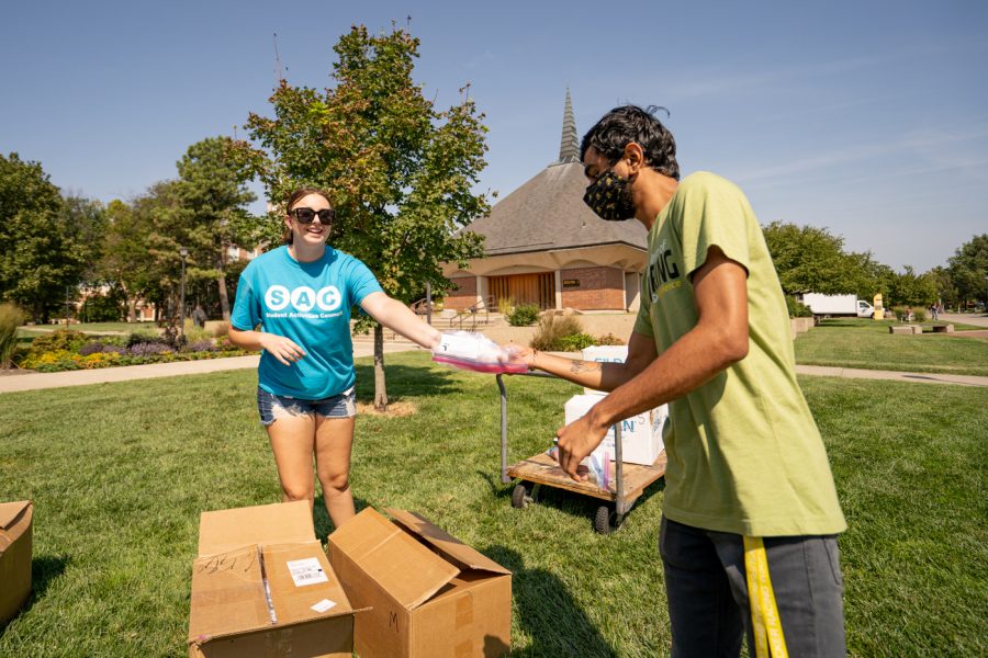 Health Management Junior hands a shirt to a student during Tie-Dye Tuesday. The event was held on Sept 7 in front of the RSC.