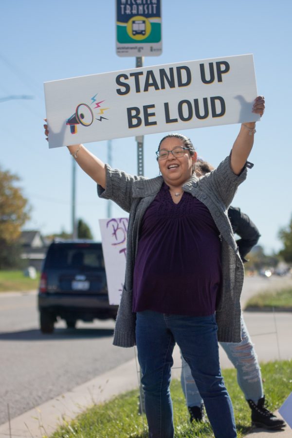 A Wichita local holds a sign to support Professor Karen Countryman-Roswurm, harrassment victium. The protest was filled with students, faculty, and Wichita locals outside of the Metroplex on Oct. 29.