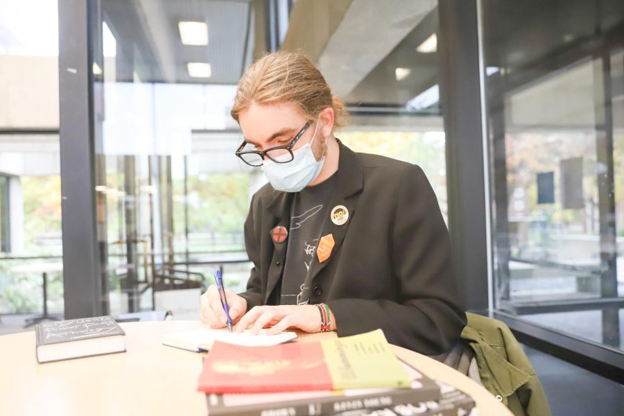 Jouquin Fox, president of the Fairmount College Student Advisory Committee, writes poetry in Ablah library on Nov. 10, 2021.  He is a junior junior double majoring in creative writing and English language and literature.