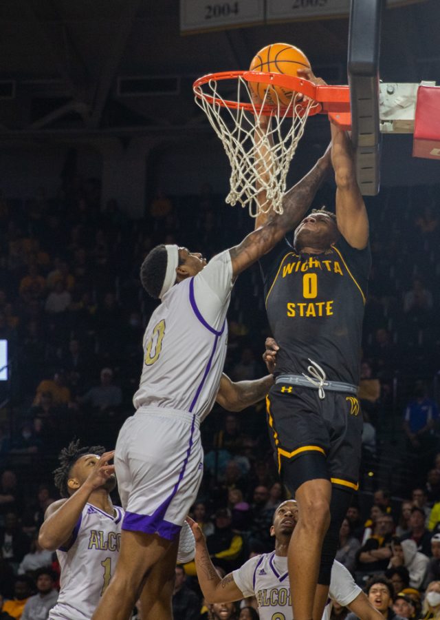 Junior Dexter Dennis dunks the ball in despite the Alcorn player pulling him down during the game against Alcorn at Charles Koch Arena on Dec. 14.