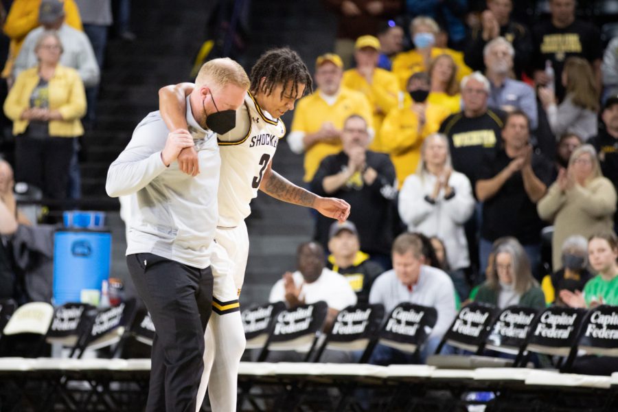 Athletic trainer Todd Fagan helps junior Craig Porter Jr. off the court after injuring his ankle. Porter scored a team-high of 10 points in the first 20 minutes of the game.